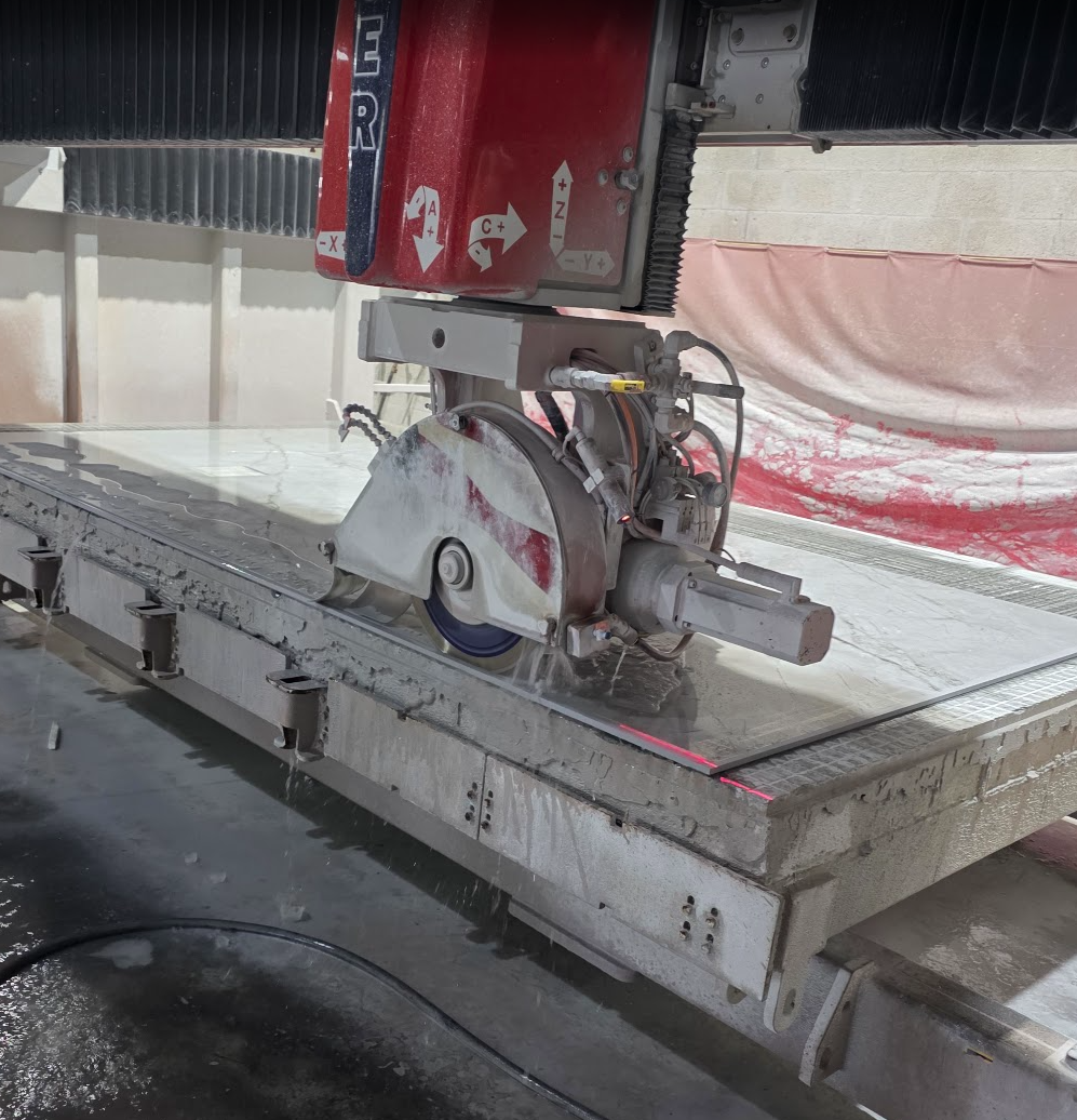 Real bridge saw cutting a stone slab in a fabrication shop